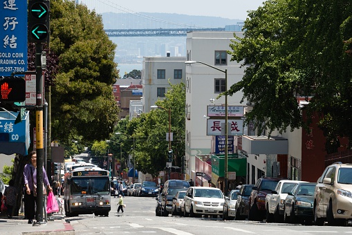 San Francisco, USA - May 29, 2014:  People in the Chinatown section in San Francisco with San Francisco Bay, and Bay Bridge in the background.