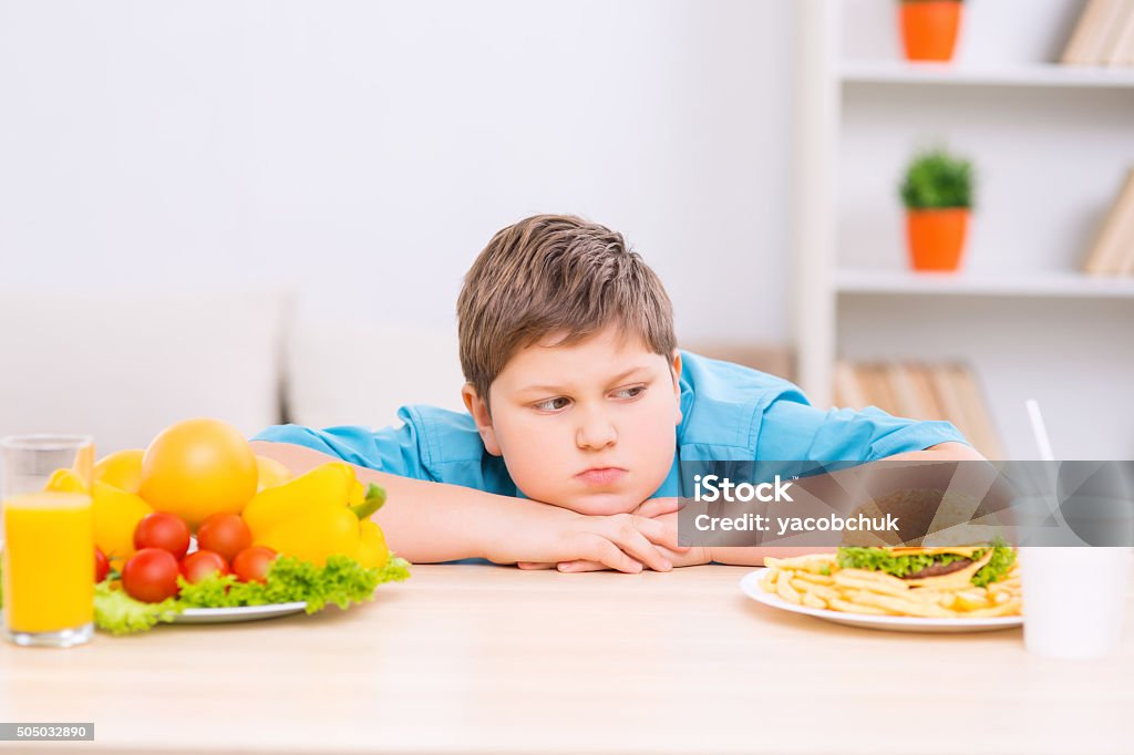 Extracorto niño está examinando basura de alimentos en placa - Foto de stock de Gordo - Complexión libre de derechos