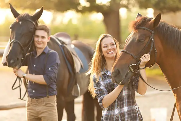 Young couple enjoy spending time together with horses