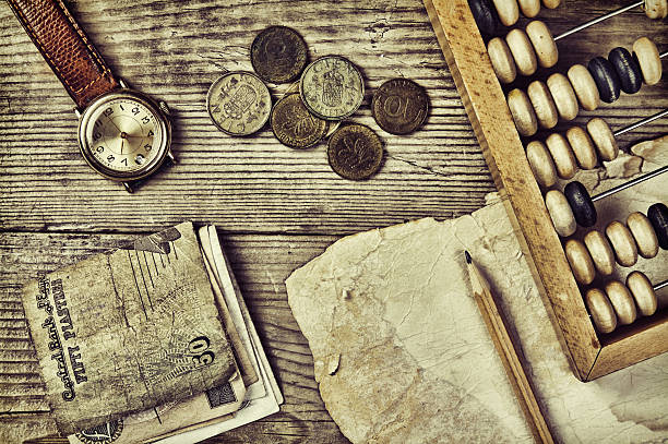 istock Old notes and coins and abacus on a wooden table 505045545
