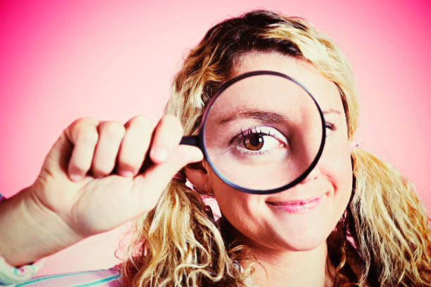 istock Look at that! Cute blonde geeks peers through magnifying glass 505048553