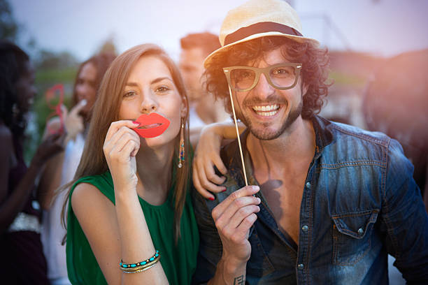 Friends having fun outdoors. Friends having fun outdoors at night club, holding masks in moustache, glasses, tie and etc. shapes. women movember mustache facial hair stock pictures, royalty-free photos & images