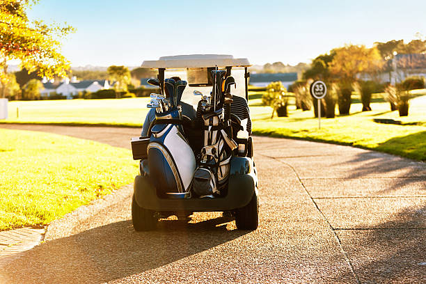 istock Golf cart laden with bags drives on path through golfcourse 505052207