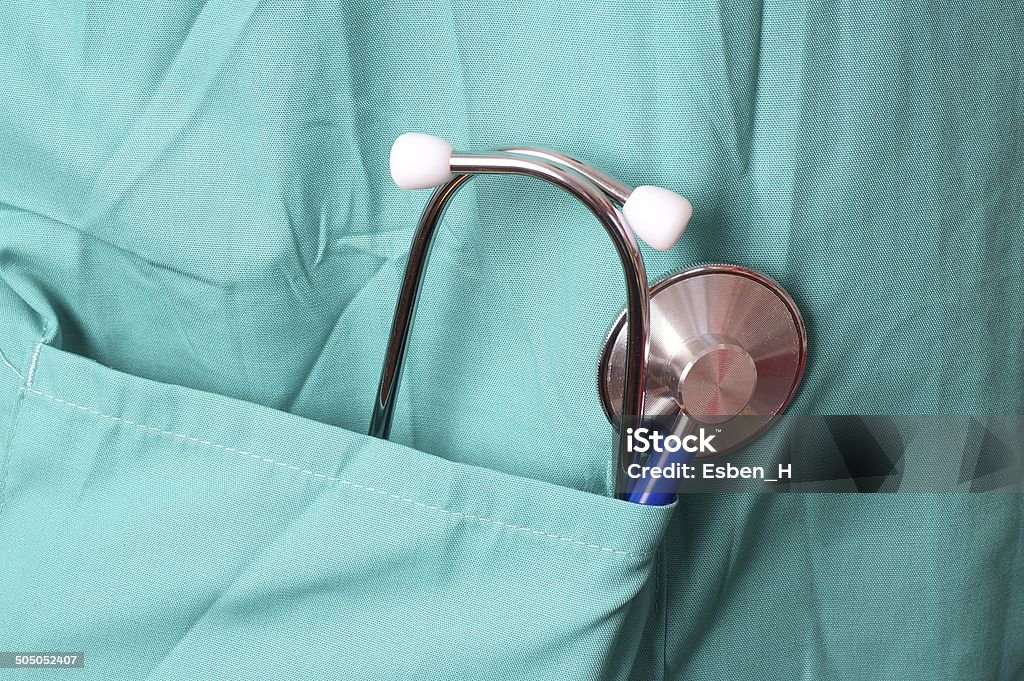 Surgeon with stethoscope in pocket Surgeon with stethoscope in pocket, isolated on green background Adult Stock Photo