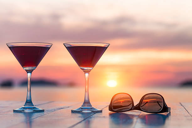 due cocktail e occhiali da sole in un ristorante sulla spiaggia, luna di miele, tramonto - glass bar relaxation red foto e immagini stock