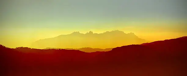 Panorama of Montserrat mountains floated at warm light of sunset