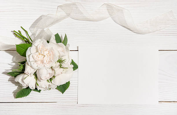 istock bunch of white roses on white table with empty card 505059734
