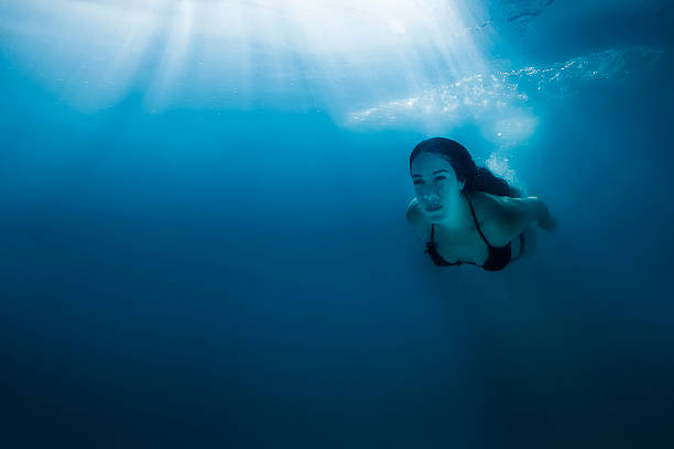 istock Pretty Girl Diving Underwater Under Bright Sunrays 505060528