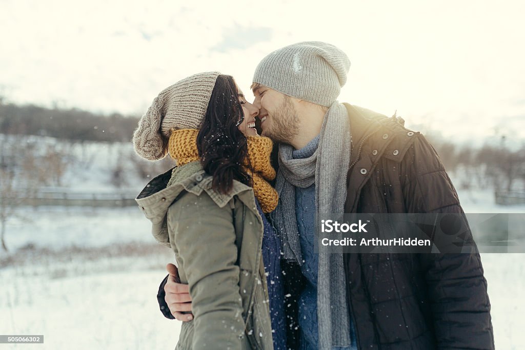 Cheerful young couple walking in a winter day Cheerful young couple walking in a winter day. Young loving couple on natural winter background Adult Stock Photo
