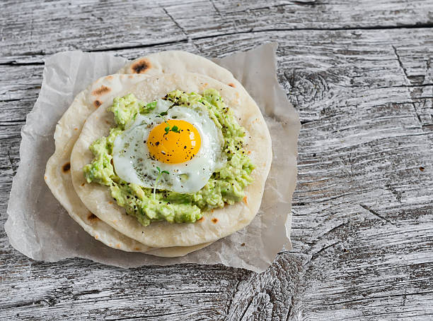 istock Homemade tortilla with mashed avocado and a fried quail egg. 505067346
