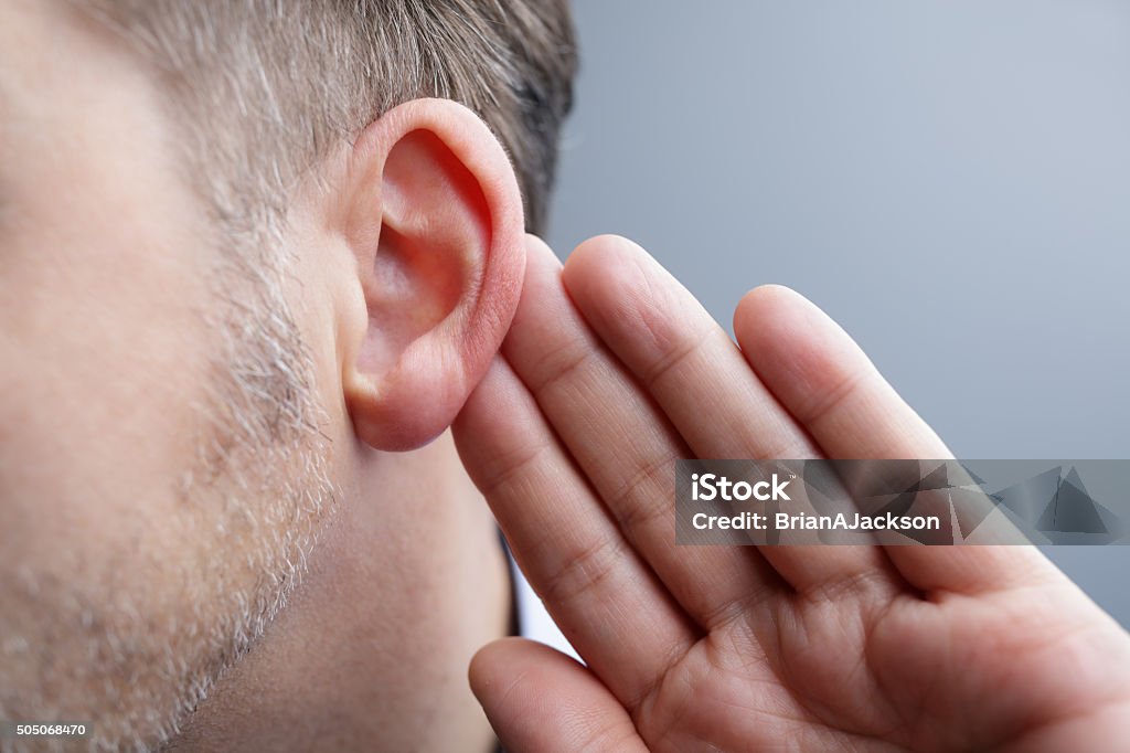 Listening Man with hand on ear listening for quiet sound or paying attention Listening Stock Photo