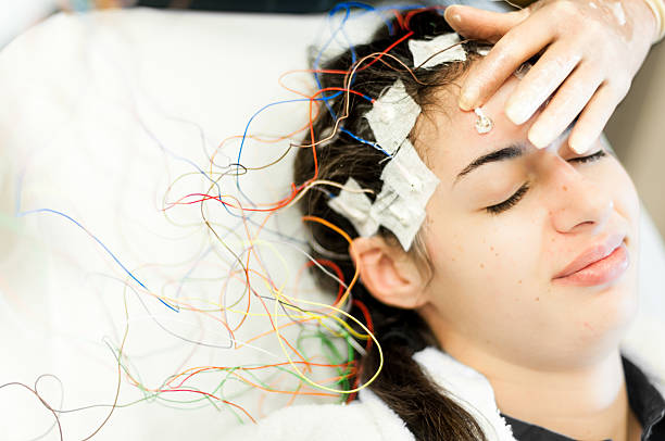 mujer joven teniendo un eeg de prueba - electrode fotografías e imágenes de stock