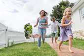 verspielte-familie-l%C3%A4uft-um-das-hau