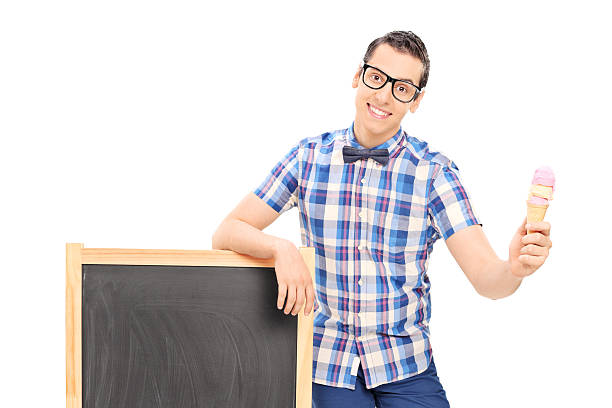 istock Young man standing by a blackboard and holding ice cream 505078761