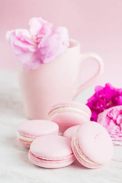 Pastel pink macaroons and tea cup with rose, pastel colored, selective focus