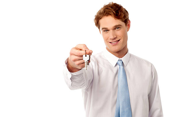 istock Smiling man offering house key 505081363