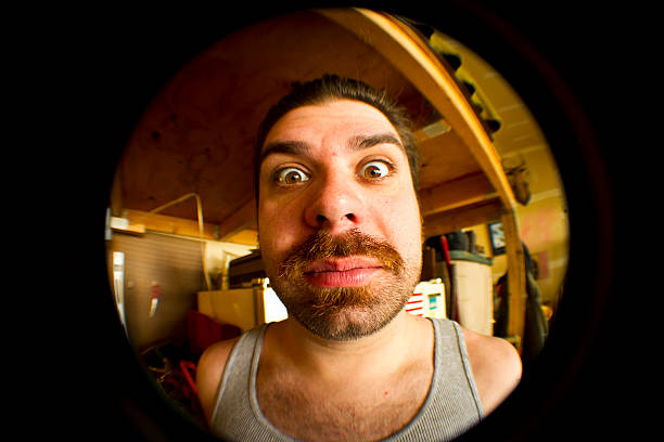 istock Goofy man looking through tube. 505082491
