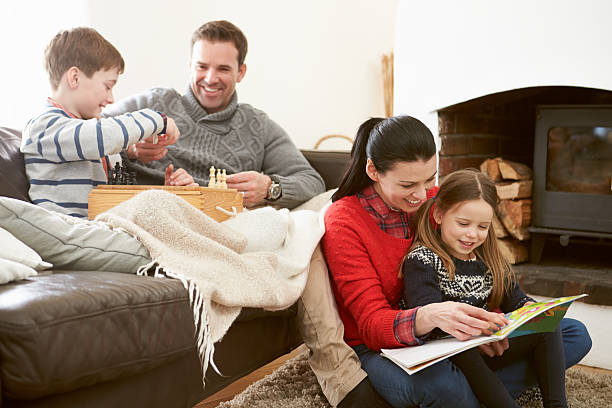 familie entspannung im freien spielen schach und liest buch - family four people smiling autumn stock-fotos und bilder