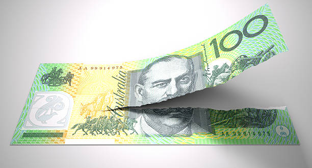 Tearing Australian Dollar Note A concept picture of a regular australian one hundred dollar note tearing in two length ways on an isolated background desecrate stock pictures, royalty-free photos & images