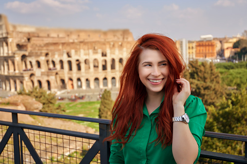 portrait of red hair woman feeling joyful and smiling, enjoying her day in Italy, Rome.travel and lifestyle conceptual photo taken outdoors.