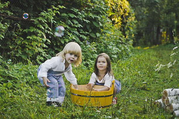 istock Girl and boy playing outdoors with soap bubbles 505090748