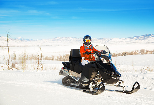 Woman driving a snowmobile in Colorado, USA - panning motion blur
