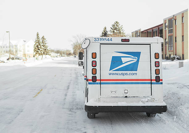 United States Postal Service van parked on icy street Moorhead, Minnesota, United States - January 16, 2016: USPS, United States Postal Service, van parked on suburban street during winter with lots of snow.  united states postal service photos stock pictures, royalty-free photos & images