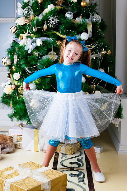 istock Girl standing next to Christmas tree 505097616