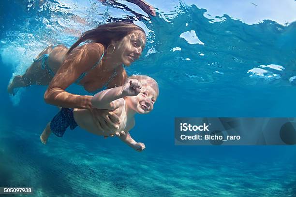 Mother With Child Swim Underwater In Blue Beach Pool Stock Photo - Download Image Now