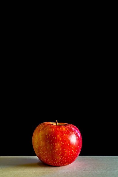 istock Red apple an a wooden board with black background 505098466