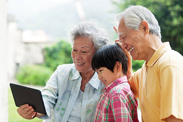 istock Grandson and grandparents taking selfie with digital tablet 505115705