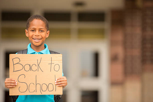 istock African descent, little boy holds back to school sign. 505115955