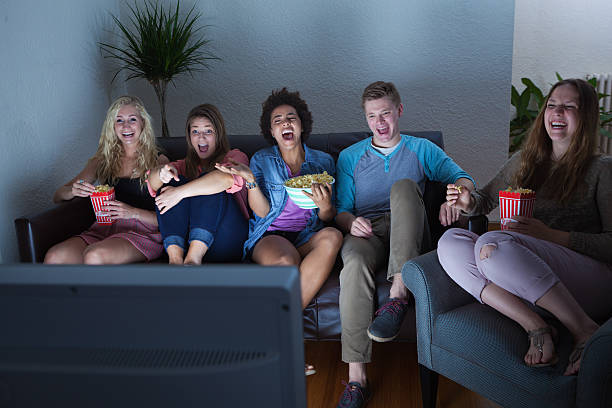 adolescente grupo de amigos assistindo humor, filme, programa de tv juntos - entertainment center watching tv television popcorn - fotografias e filmes do acervo