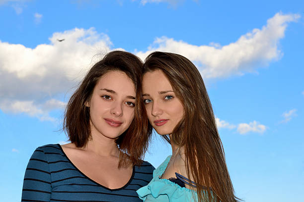 Best female friends on balcony having a nice photo time. Posing for a photographer.