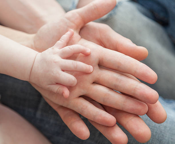 istock Father and mother holding child's hand 505118187