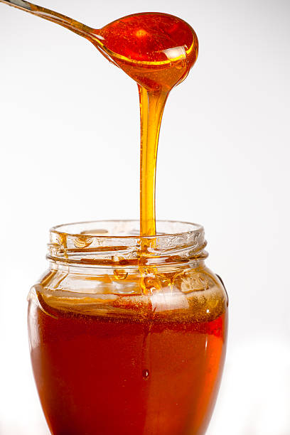 istock glass of fresh honey on white background 505123420