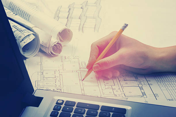 Architect working on blueprint. Architects workplace - architectural project, blueprints Architect working on blueprint. Architects workplace - architectural project, blueprints, ruler, calculator, laptop and divider compass. Construction concept. Engineering tools. Toned image.  autocad house plans stock pictures, royalty-free photos & images
