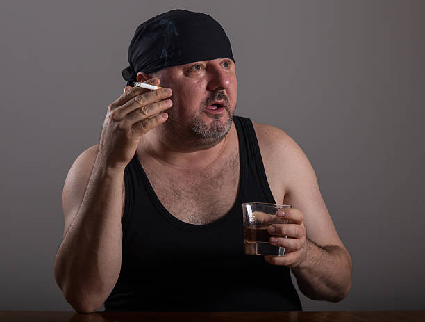 istock Adult in undershirt smokind and drinking whiskey 505126520