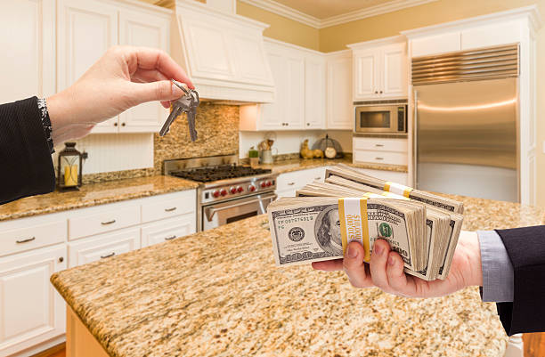 istock Handing Over Cash for Keys Inside Beautiful Kitchen 505129796