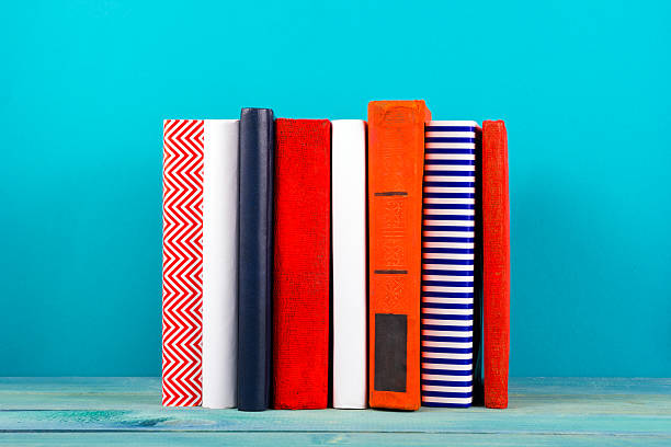 istock Row of colorful hardback books, open book on blue background 505132022