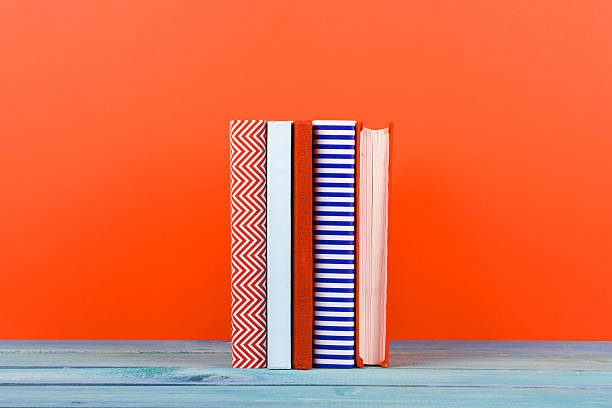 istock Row of colorful hardback books, open book on red background 505132084