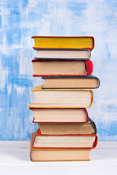 istock Stack of colorful hardback books, open book on blue background 505132558