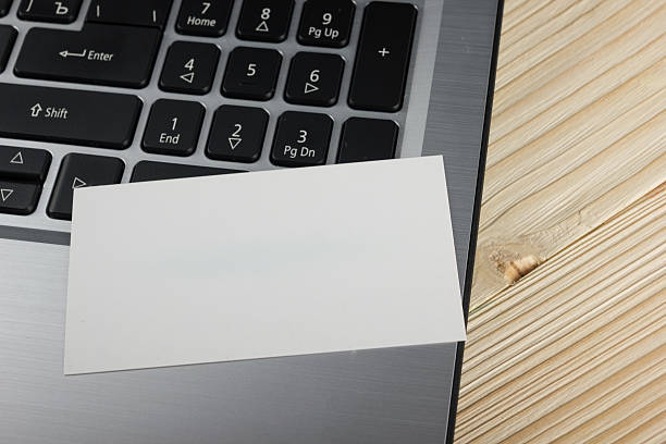 istock Business card mock-up standing up on computer on blueprint background 505132670