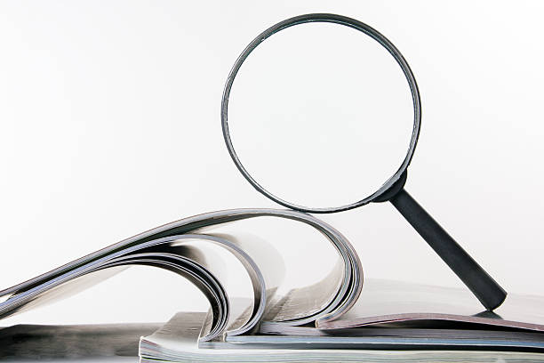 istock Architectural blueprints and blueprint rolls with magnifying glass 505133594