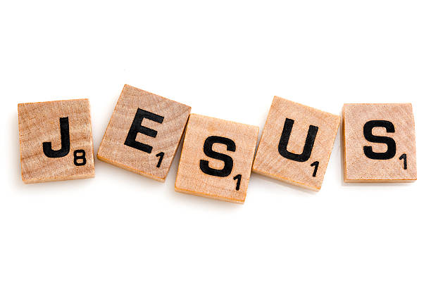 Miami, Florida, USA - May 27, 2015: Scrabble game board Lettered wooden tiles forming the Word JESUS on white background. Scrabble is a fun and educational game distributed by Hasbro
