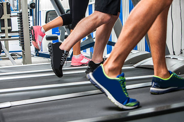 Group of legs wearing sneakers running on treadmill stock photo