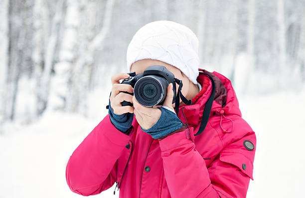 istock Young girl with the camera outdoors in winter 505137174