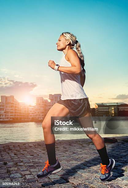 Woman Runs Through The City At Sunset Stock Photo - Download Image Now - 30-39 Years, Activity, Adult