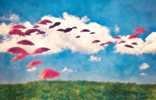 Red umbrellas flying in the sky. 