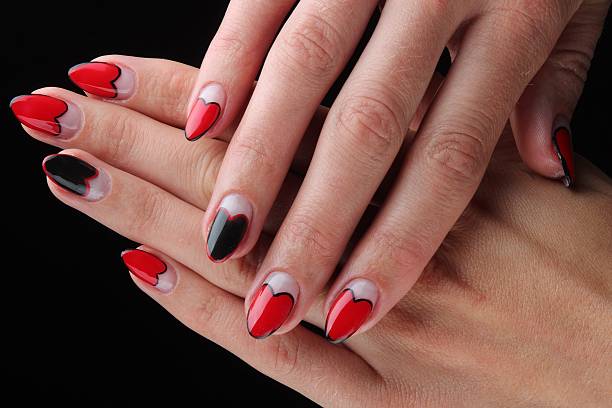 istock Red painted nails and hands isolated on black background 505147289